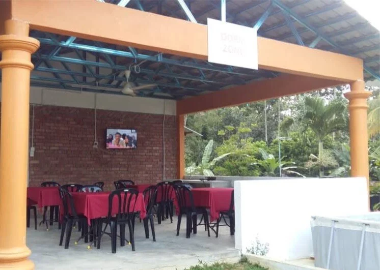 Dorm Hall with red table sets under a covered veranda